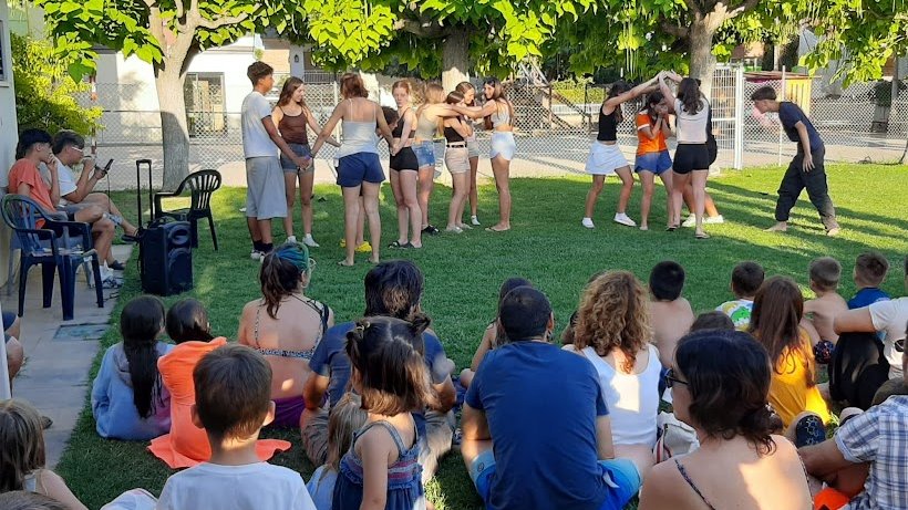 Els nois i noies del camp de treball expliquen contes a les piscines del Palau d'Anglesola